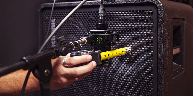 LEWITT microphone is getting positioned in front of bass amp
